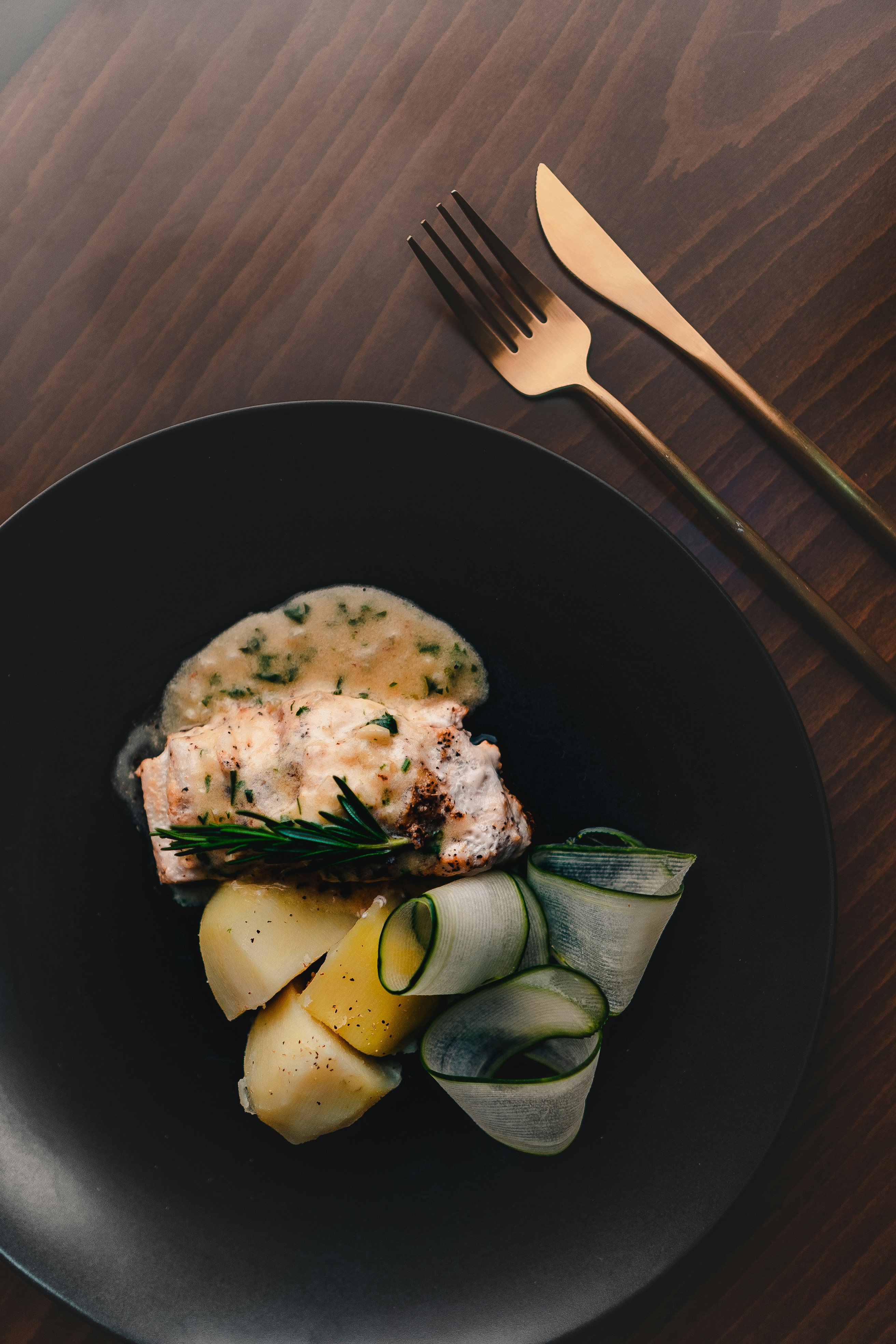 Elegant plated fish dish with silky Velouté sauce, served with potatoes and cucumber ribbons